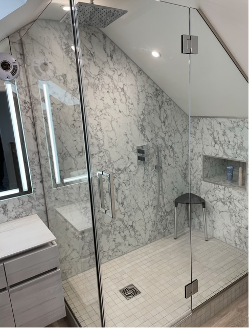 Marble shower enclosure with glass panels